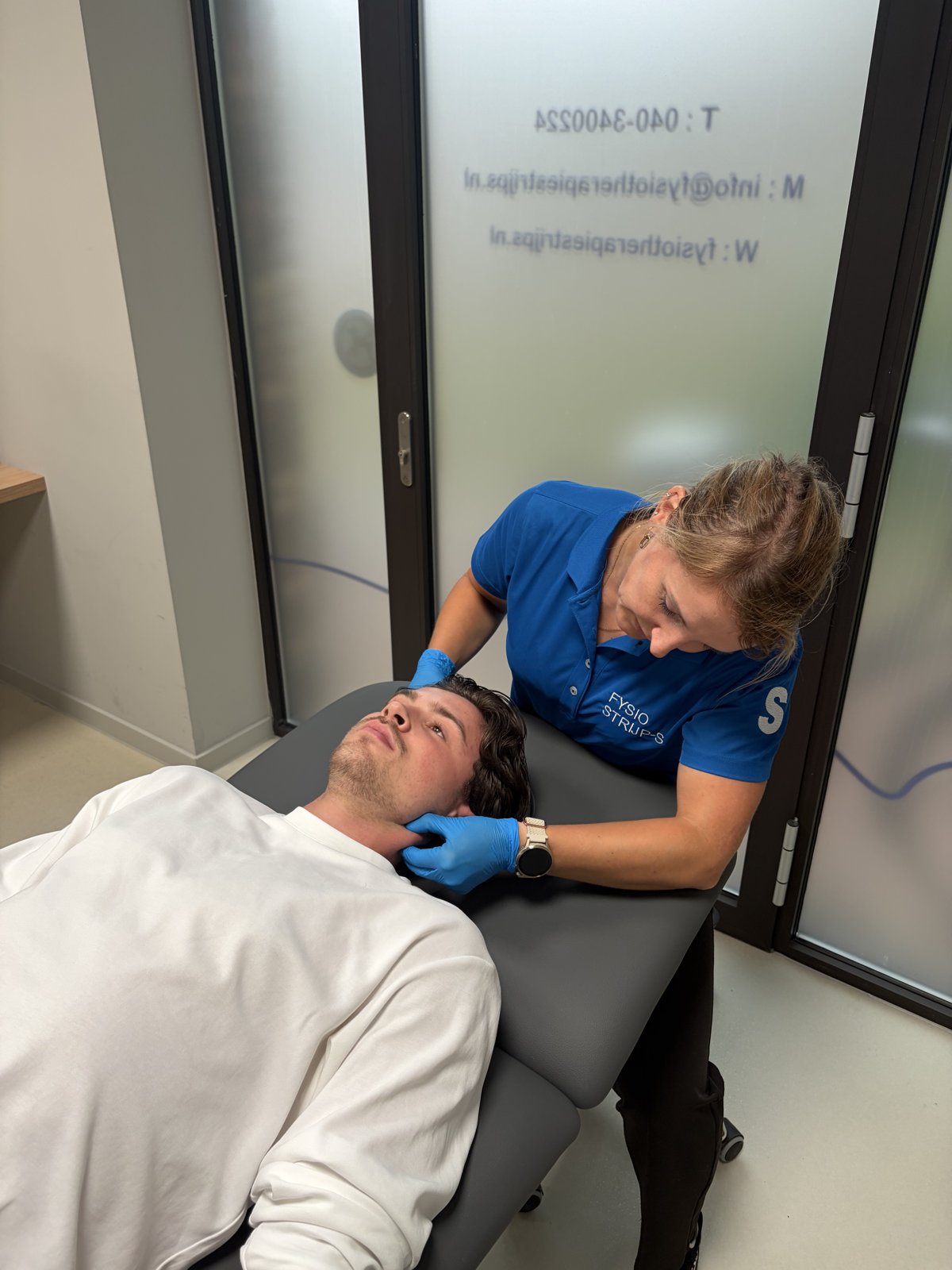 Kaakfysiotherapeut onderzoekt het kaakgewricht van een patiënt bij Fysiotherapie Strijp-S in Eindhoven