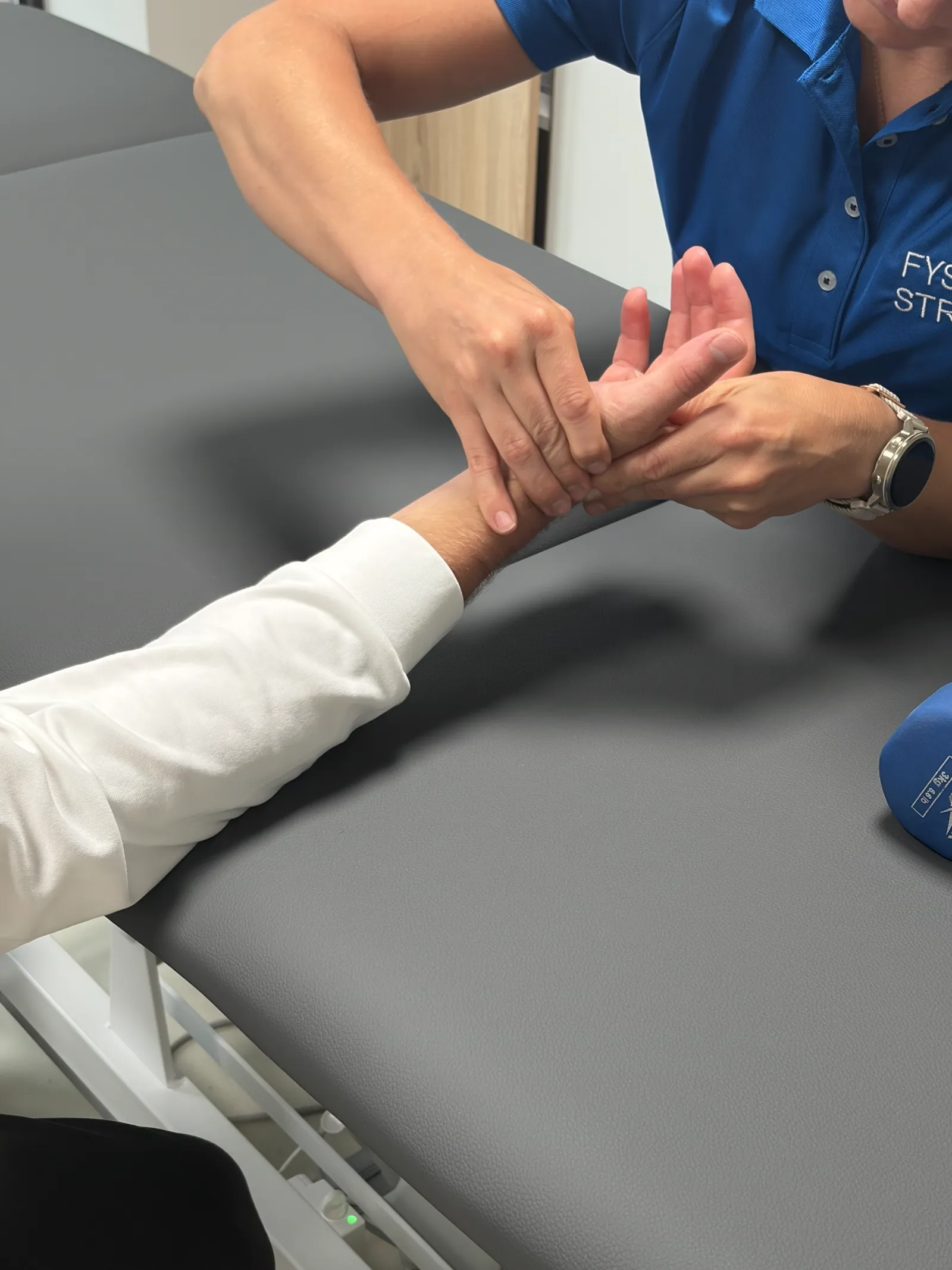 Gecertificeerd handtherapeut onderzoekt hand en pols in Eindhoven