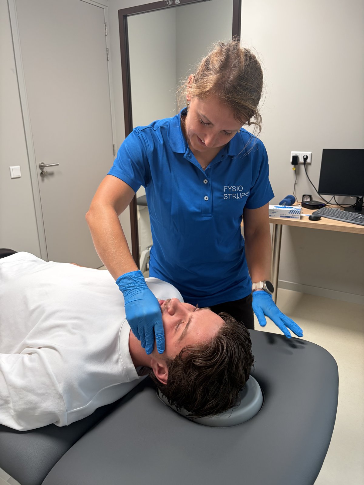 Shauni Hermans, kaakfysiotherapeut bij Fysiotherapie Strijp-S in Eindhoven, behandelt de kaak van een patiënt